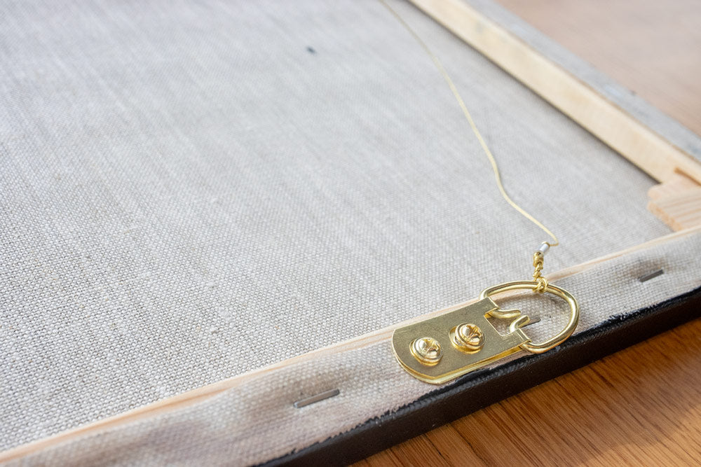 The back of the painting canvas, contains the Title and painting information, wooden stretcher bar, linen canvas, and brass hanging hardware and bumpers.