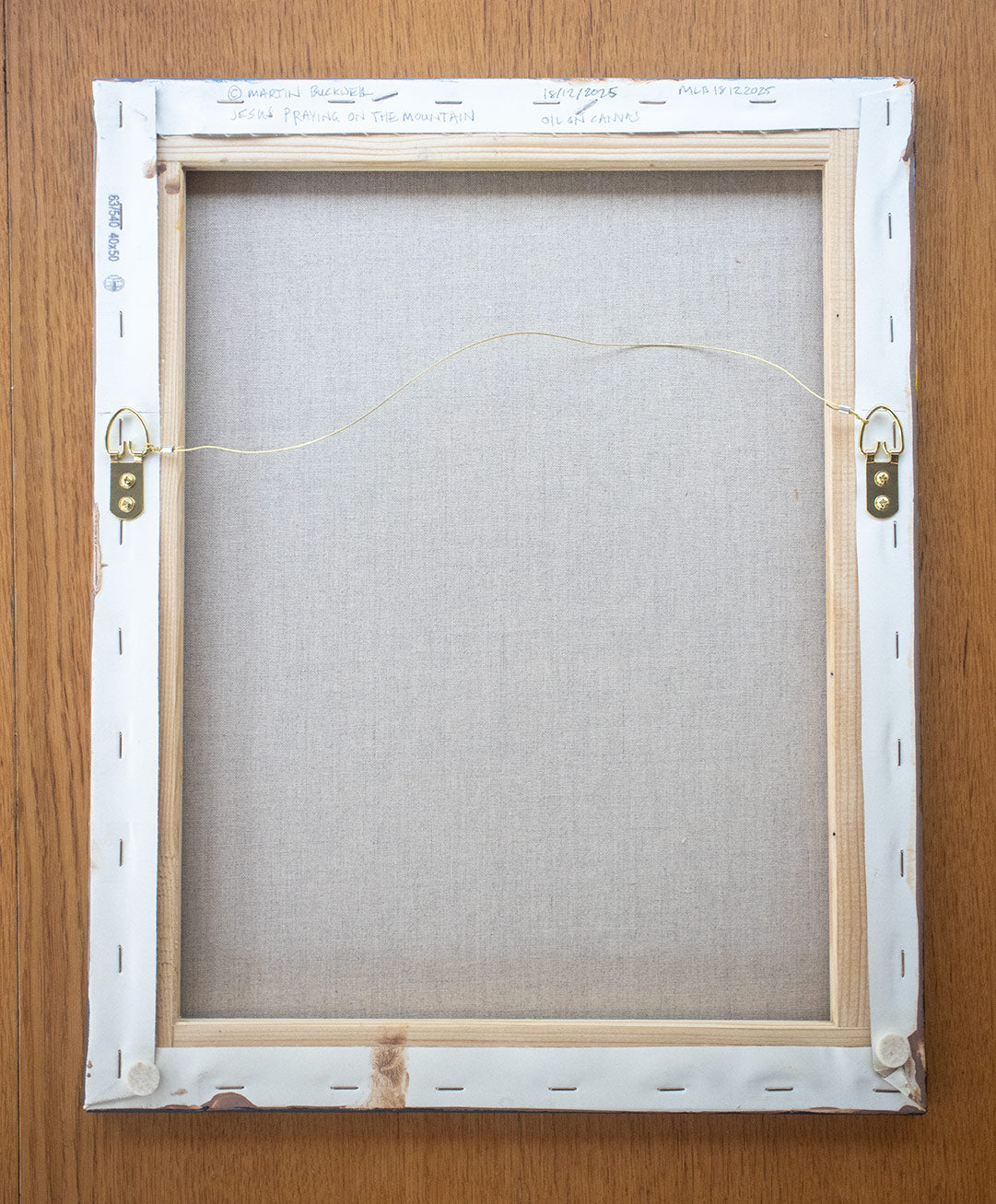 A picture of the back of Jesus on the mountain painting canvas with hangers and written title by Martin Buckwell