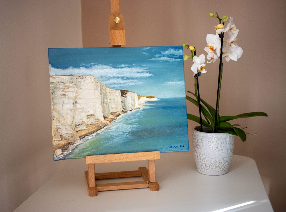 A photograph of an oil painting of the White Cliffs of Dover. 30 x 24cm canvas, on a tabletop easel, by Martin Buckwell