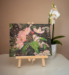A photograph of a small original oil canvas board painting on a tabletop easel, of springtime blossom in a fruit tree, United Kingdom from Martin Buckwell