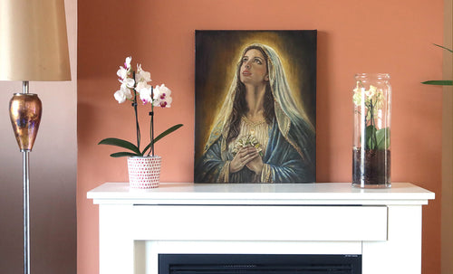 An original painting of a young Virgin Mary, the mother of Jesus set on a mantlepiece for context and scale reference